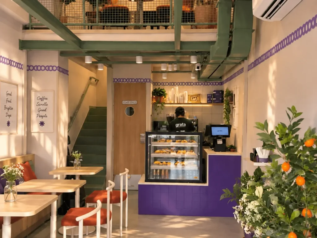 Inside Grata Bakehouse, Galleria: the counter, café tables and the stairs to the mezzanine